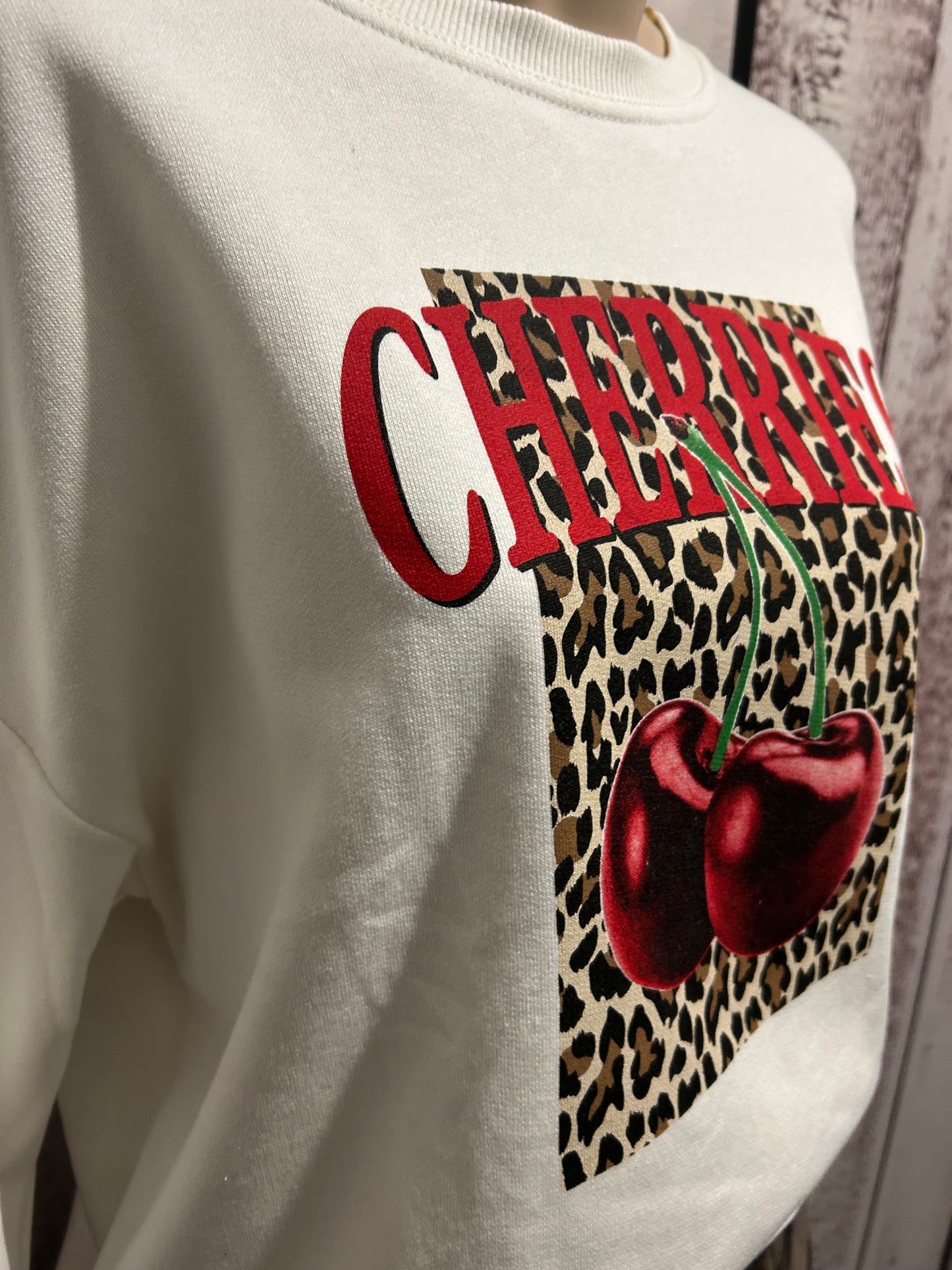 Sweat blanc motif cerises et carré léopard : un charme rétro revisité 