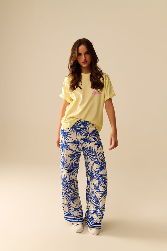 Pantalon à jambes larges en blanc avec imprimé tropical en bleu